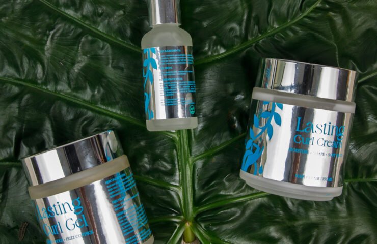 Müllwood Lasting Curl Gel jar surrounded by fresh coconuts