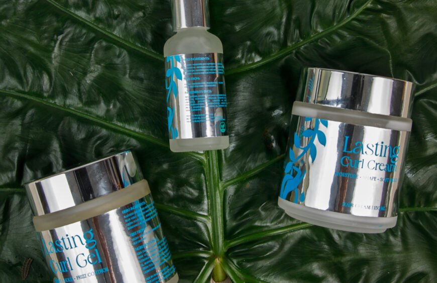 Müllwood Lasting Curl Gel jar surrounded by fresh coconuts